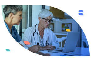 Healthcare professionals reviewing information together on a laptop during a planning meeting at a skilled nursing facility.